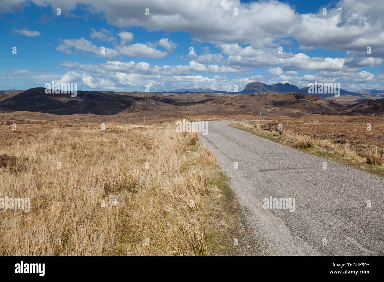Remote single track road in the Scottish Highlands with views of the distant mountains including Suilven. Stock Photo