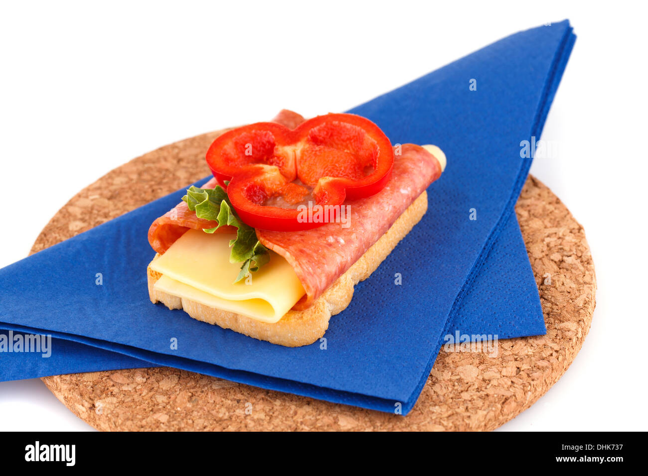 Sandwich on blue napkin on brown round board. Stock Photo