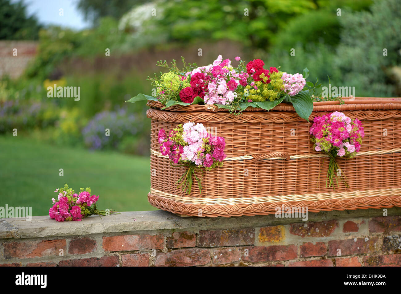 Wicker coffin with flower decoration Stock Photo