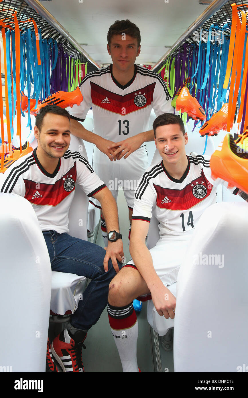 HANDOUT - A handout picture provided by adidas shows the soccer national  players Thomas Müller (C) und Julian Draxler (R) and fan Roman wearing the  new jerseys of the German national team