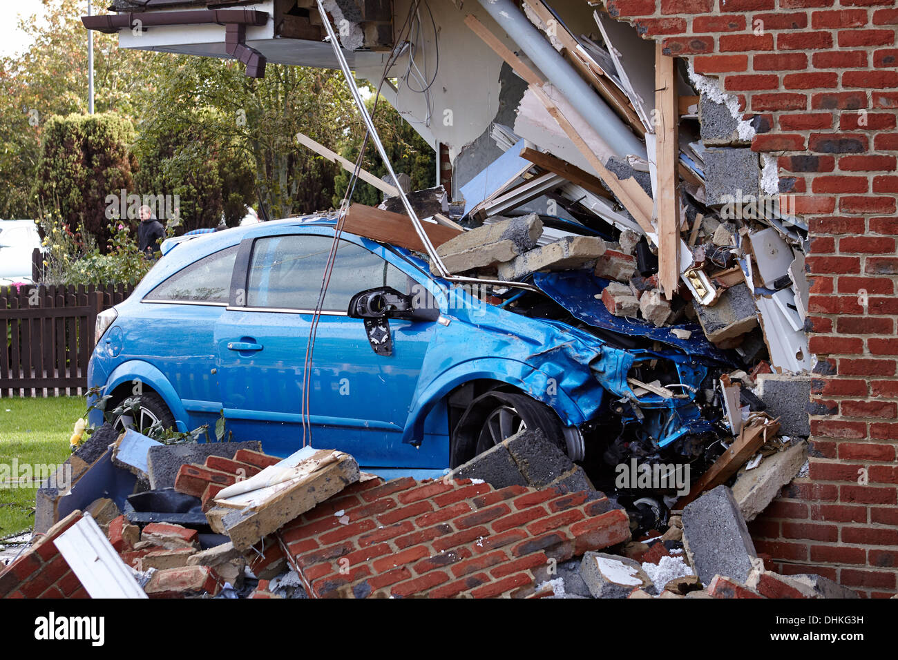 A blue car crashed into a house causing extensive damage Stock Photo