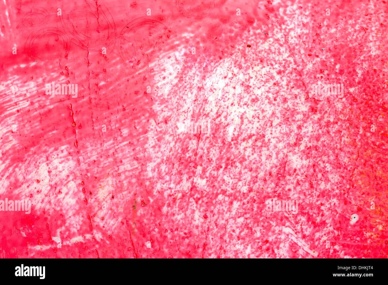 Close view of a surface covered with worn red paint. Stock Photo