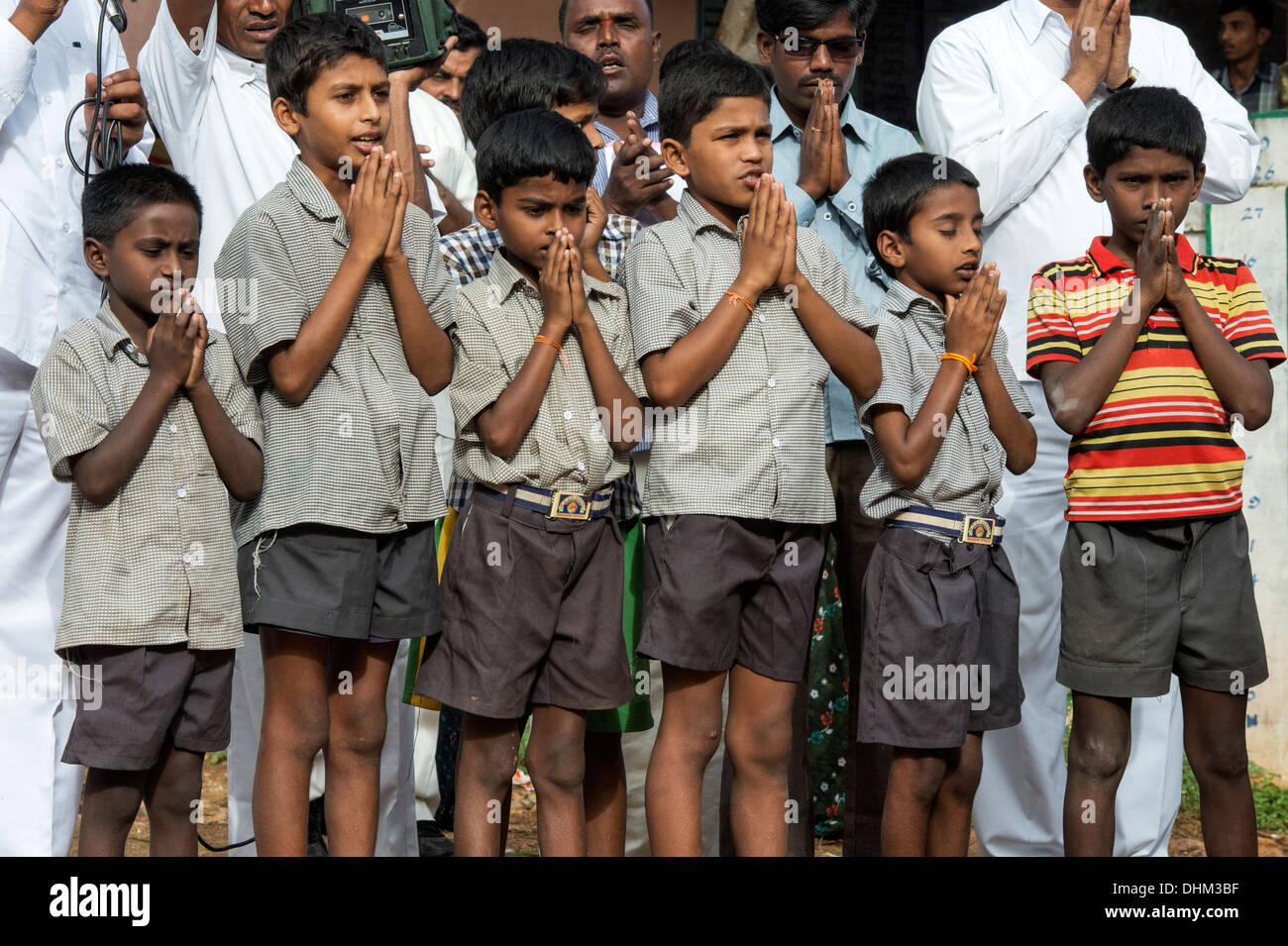 Rural Indian school boys sing devotional songs at Sri Sathya Sai Baba mobile outreach hospital service. Andhra Pradesh, India. Stock Photo