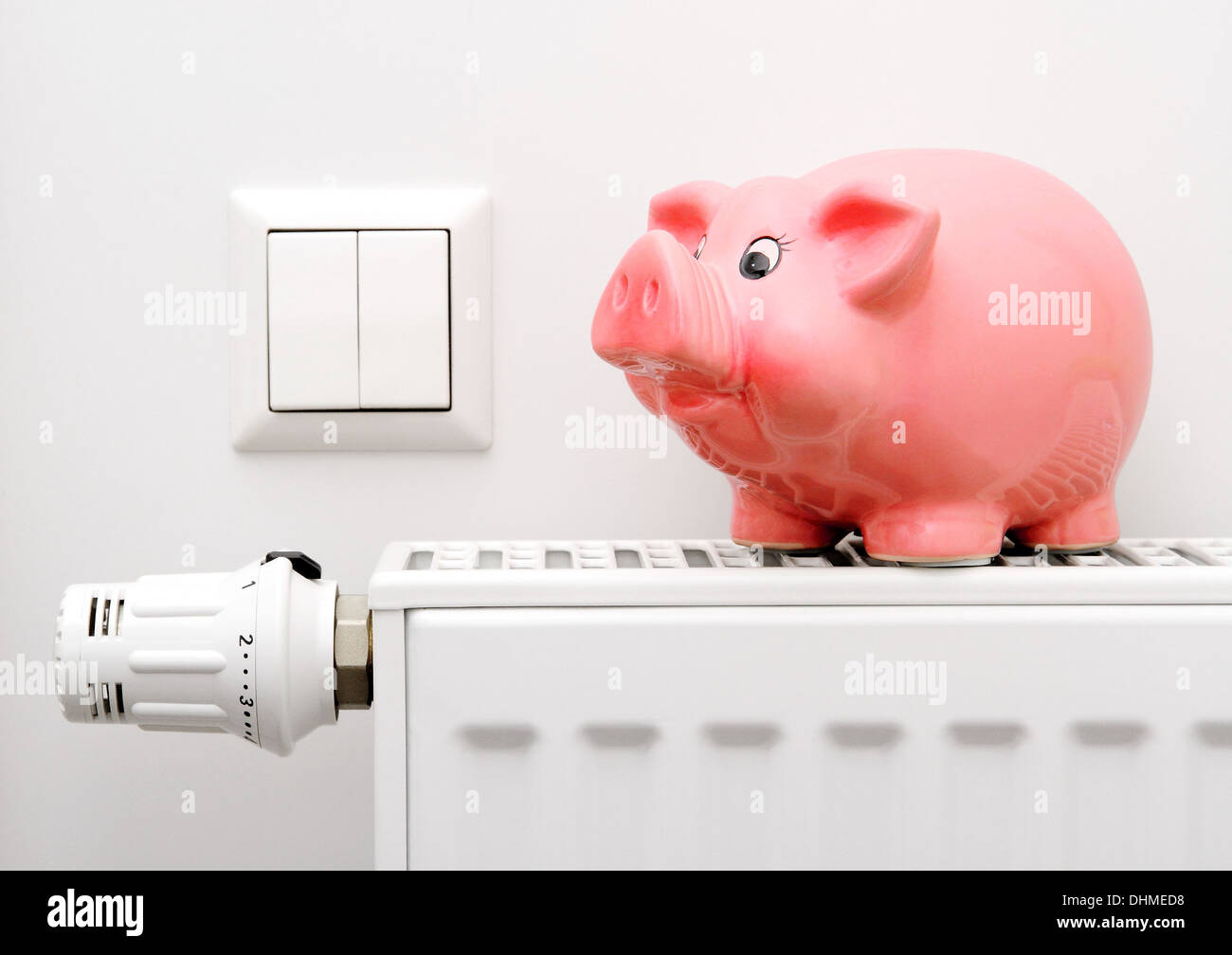 Pink piggy bank saving electricity and heating costs, close up Stock Photo