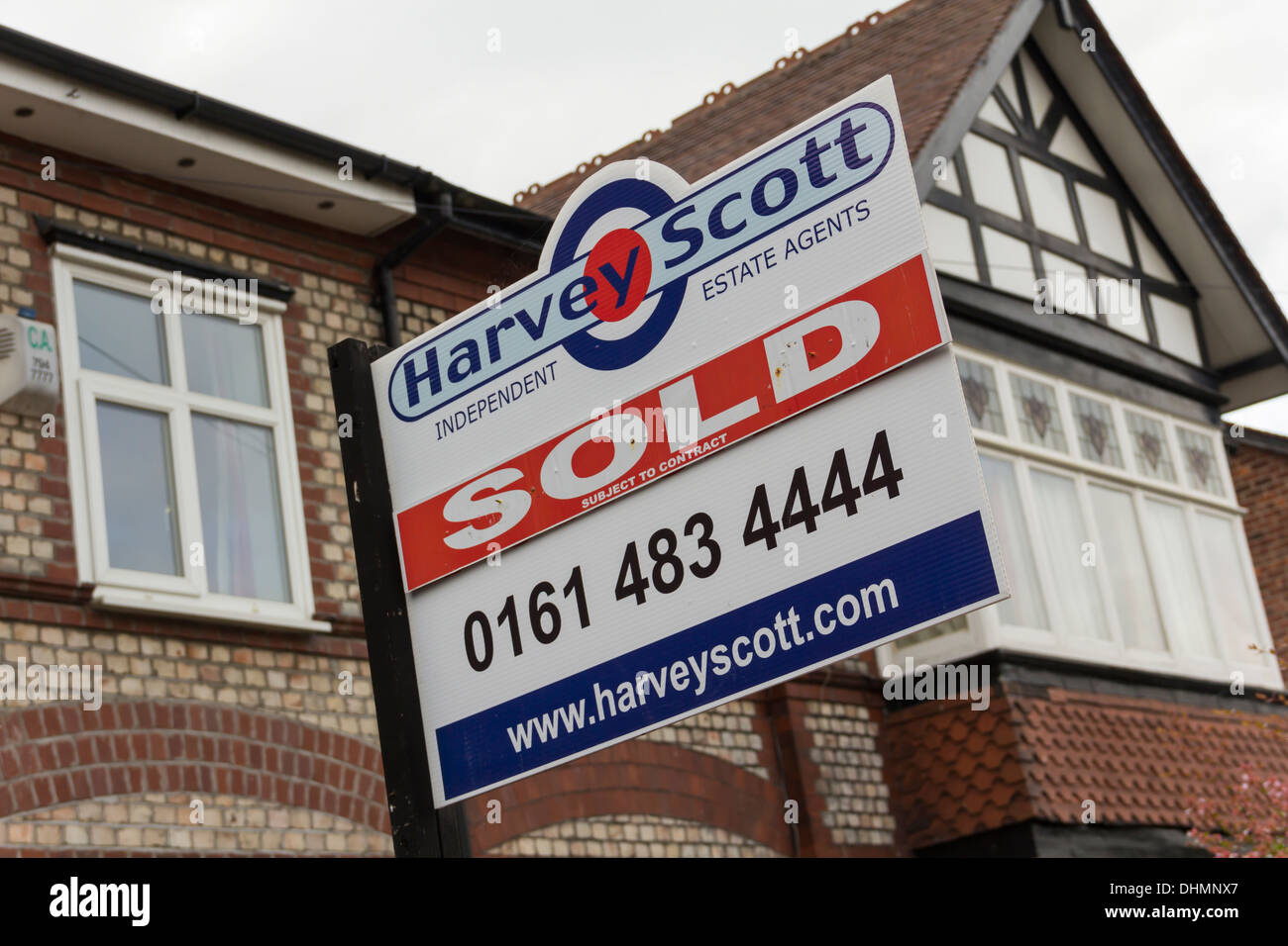 House sold sign on a early 20th century two-tone brick house with half-timber style gable window in Stockport, England. Stock Photo