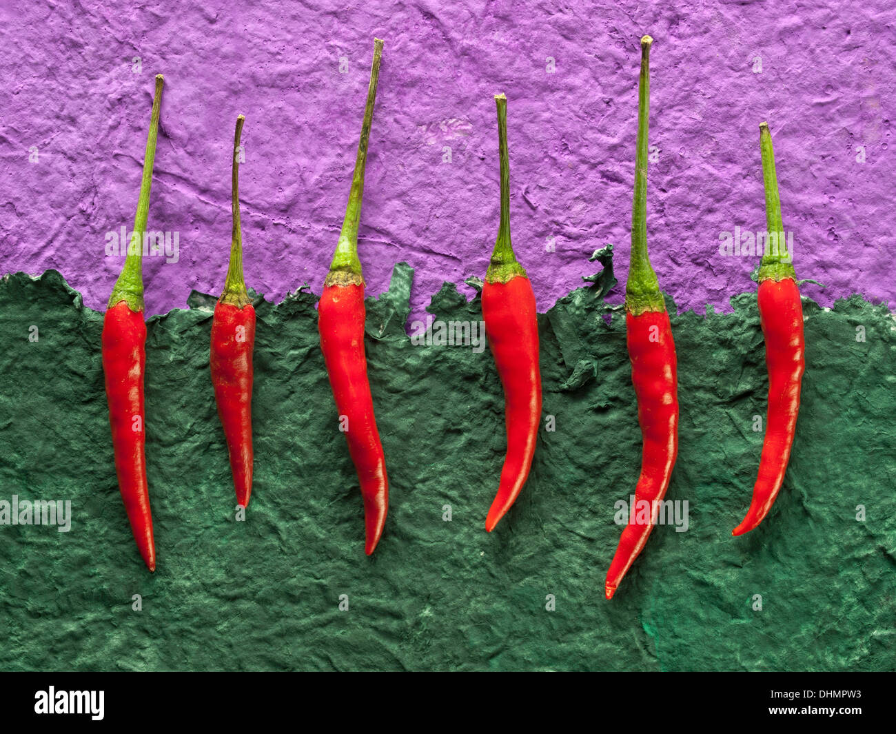 Chilli Peppers on coloured paper backgrounds Stock Photo