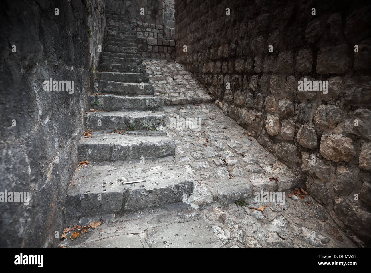 Old stone stairway goes up on the street of Perast town, Montenegro Stock Photo