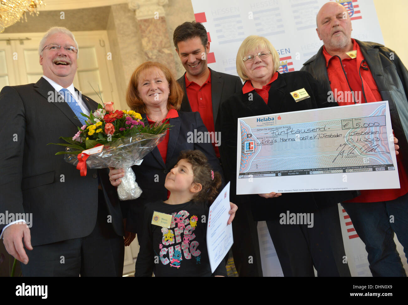 The Hessian Minister of Integration Jörg-Uwe Hahn (FDP, L) hands over a cheque to Gabriele Abshagen (L-R) four year old Merve Eroglu, Michael Abshagen, Monika Munser and Rolf Meyer of 'Erica's Manna Mobil Wiesbaden'. This year four exemplary integration projects for families are being awarded. Photo: ARNE DEDERT Stock Photo