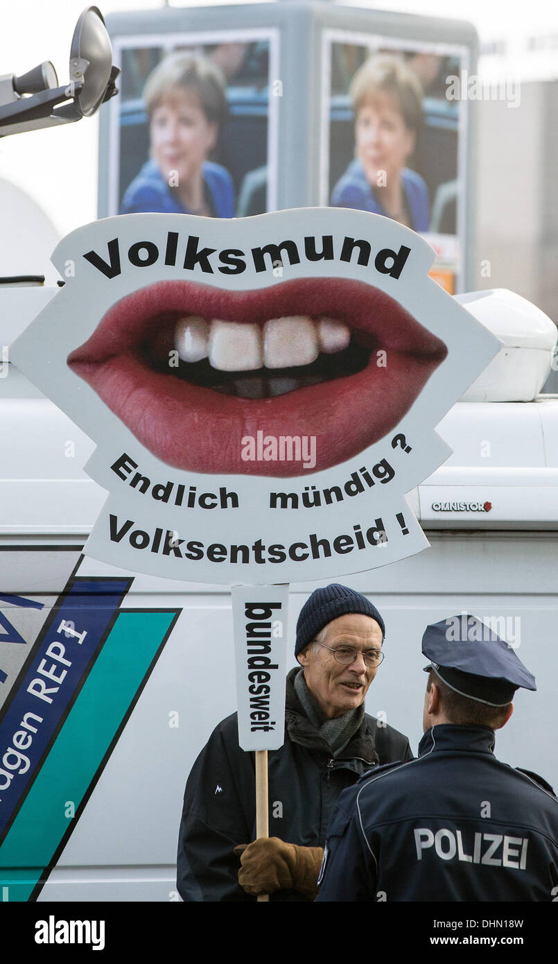 Berlin, Germany. 13th Nov, 2013. A man holds up a sign with the slogan 'Volksmund- Endlich mündig? Volksentscheid! bundesweit' (lit. people's voice - mature at last? plebiscite! nationwide) in front of the CDU party headquarters in Berlin, Germany, 13 November 2013. The action goes along with the protestors demand of a nationwide plebiscite. At the fifth large round of negotiations at the Konrad-Adenauer-Haus, CDU, CSU and SPD talk about a possible coalition. Photo: MICHAEL KAPPELER/dpa/Alamy Live News Stock Photo