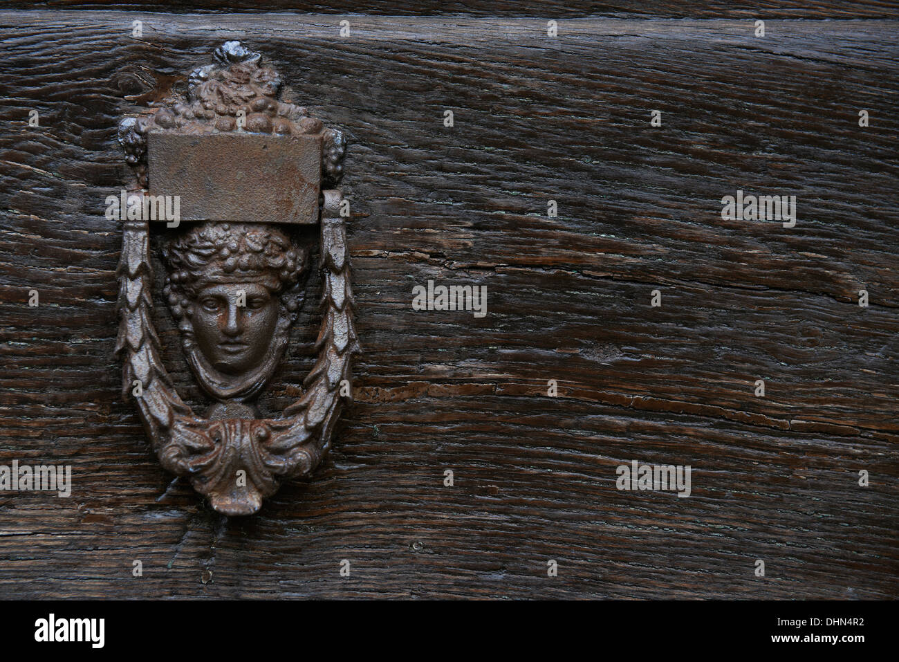 Door Knocker in cast iron on wooden door with a Classical woman face as the main design Stock Photo