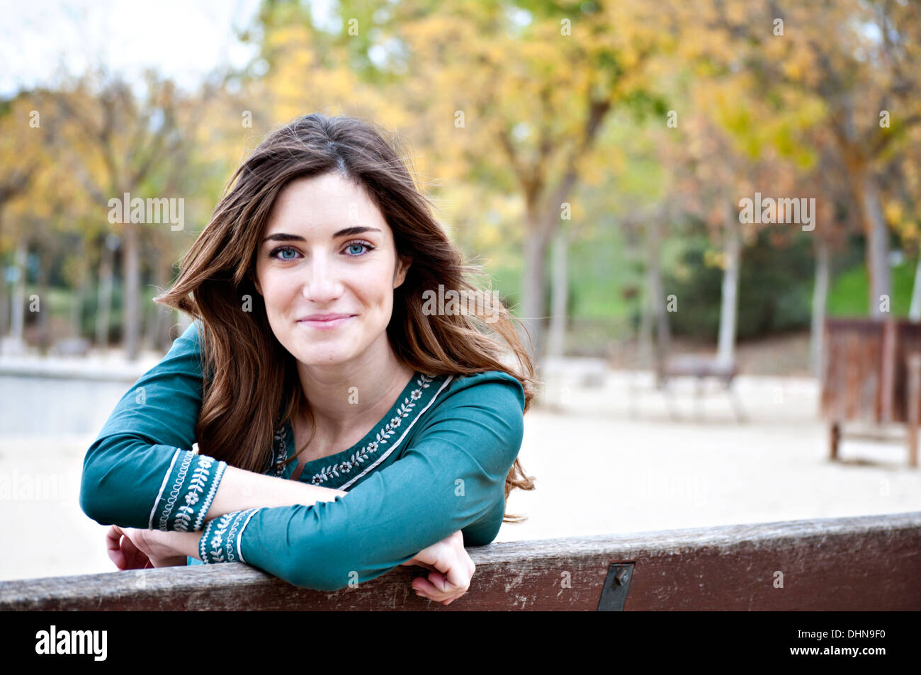 Attractive spanish woman with blue eyes in a park with tree background and copy space on right Stock Photo