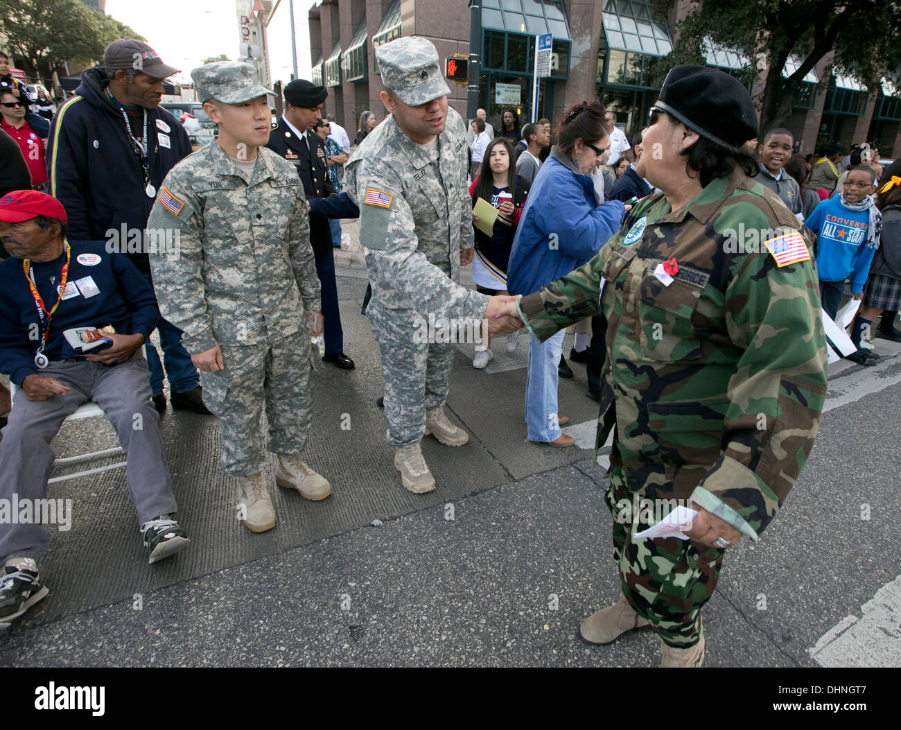 Vietnam war male Hispanic veteran, greets, shakes hands with crowd, children during a Veteran's Day parade Stock Photo