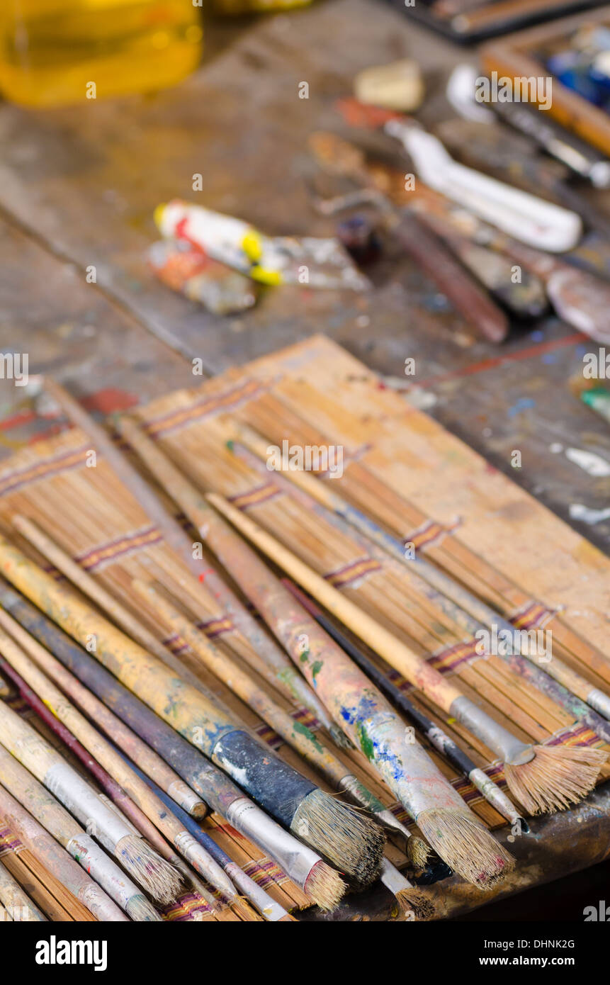 Messy atelier table with many paintbrushes and other stuff Stock Photo ...