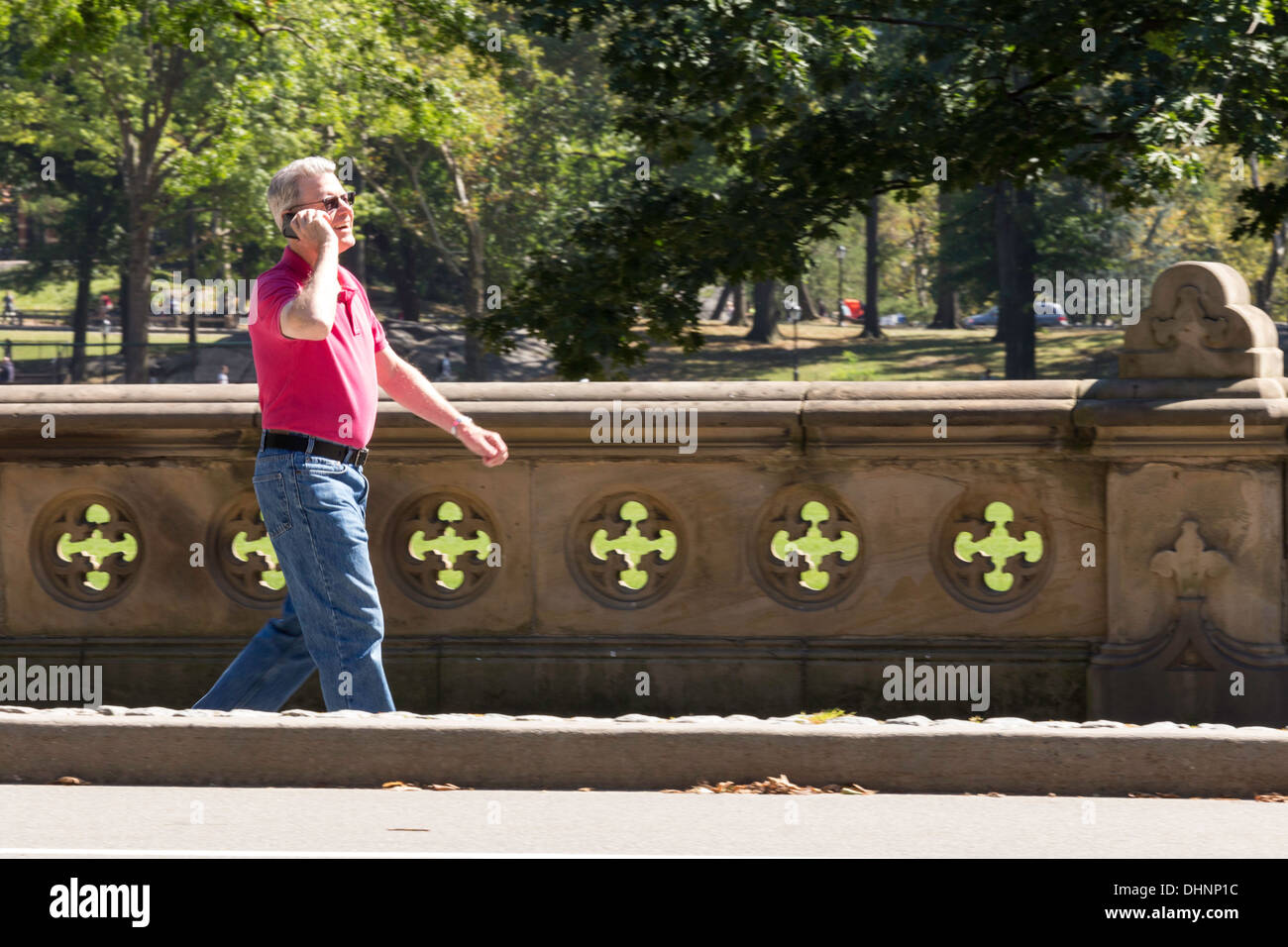 Senior Man Talking on Cell Phone while Walking in Central Park, NYC Stock Photo