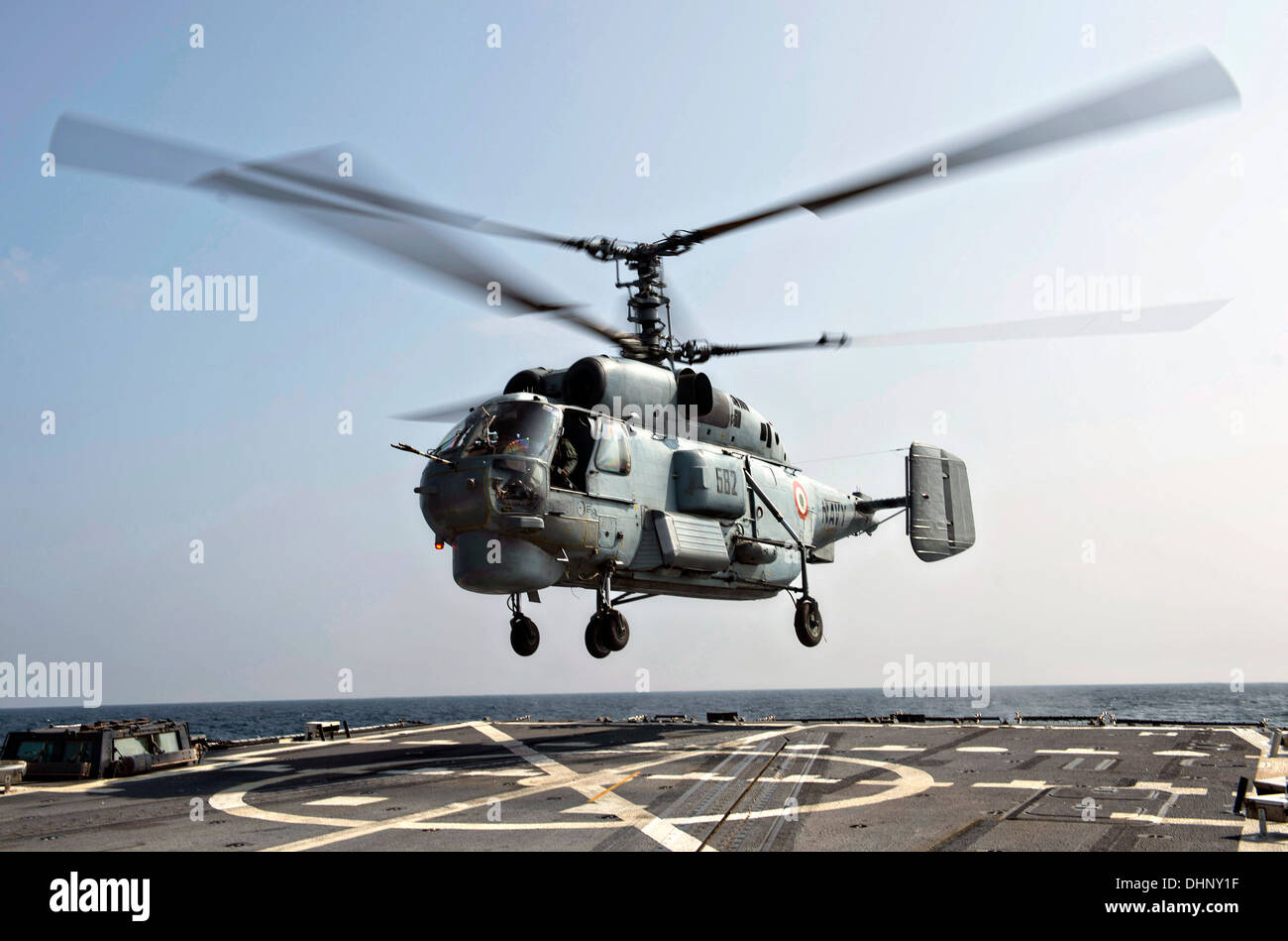 An Indian Navy KV-28 Helix helicopter lands on the flight deck of the Arleigh Burke-class guided-missile destroyer USS McCampbell during exercise Malabar November 7, 2013 operating in the Bay of Bengal. Stock Photo