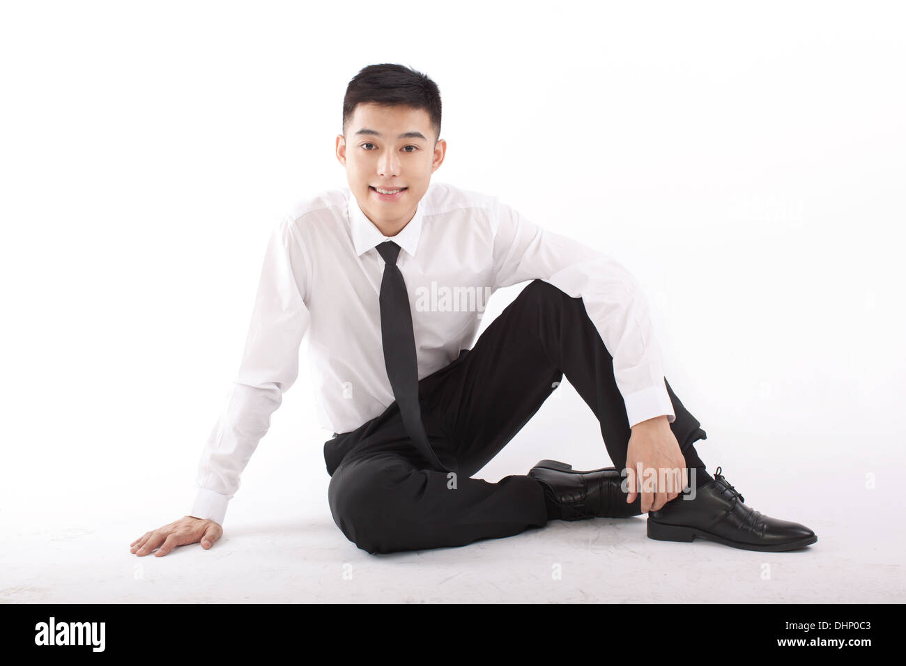 Young businessman sitting on floor near a laptop Stock Photo