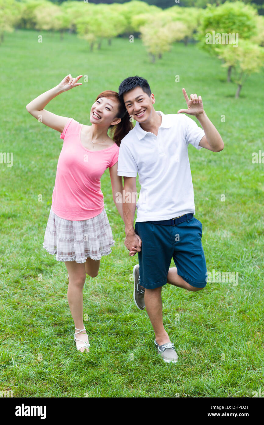 Happy young couple having fun in park Stock Photo - Alamy