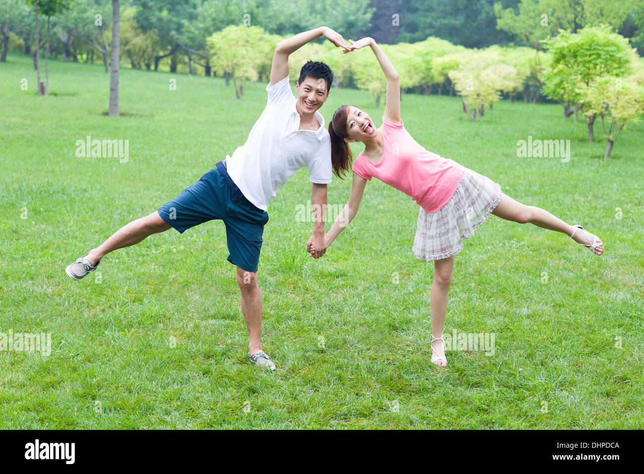 Sweet young couple making heart shape with arms Stock Photo - Alamy