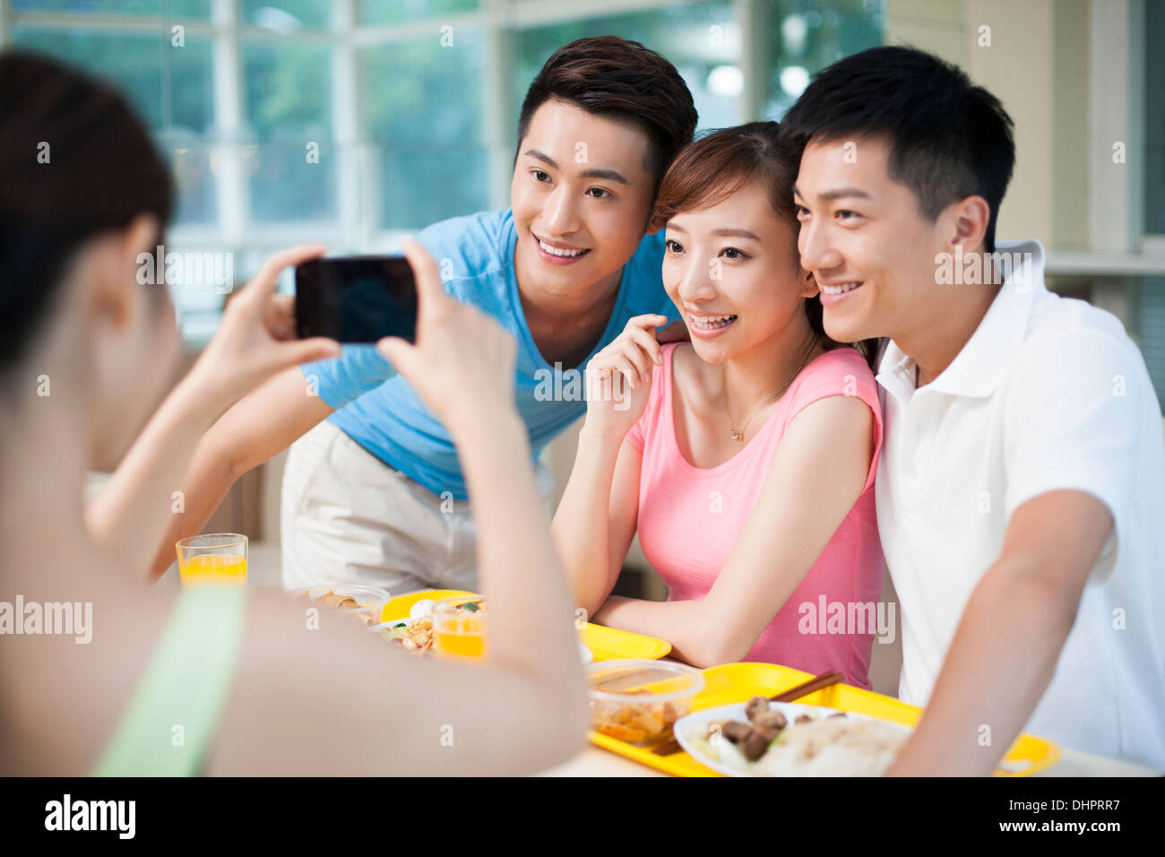 Young adults taking pictures in restaurant Stock Photo