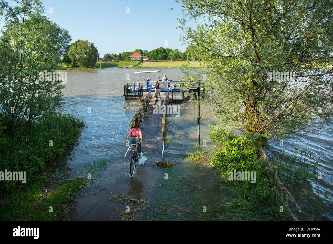 Netherlands, Zalk, Small ferry for pedestrians and cyclists crossing the IJssel river during high water Stock Photo