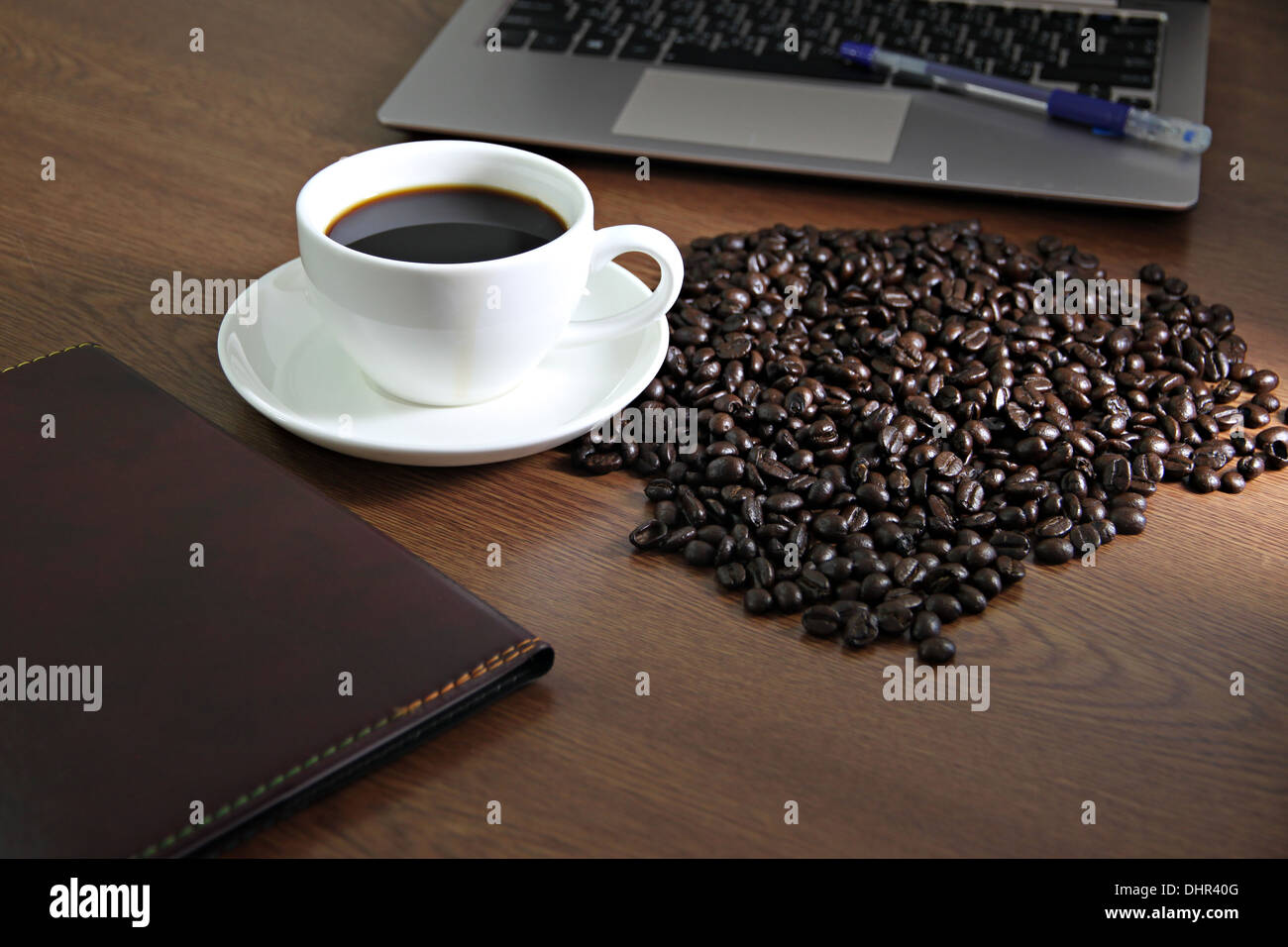 Picture focus on Coffee in white cup nearby the computer notebook. Stock Photo