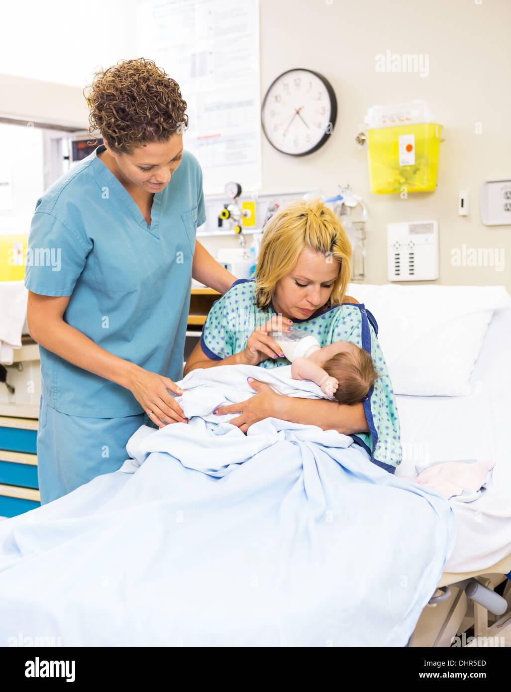 Nurse Looking At Patient Feeding Milk To Baby At Hospital Stock Photo