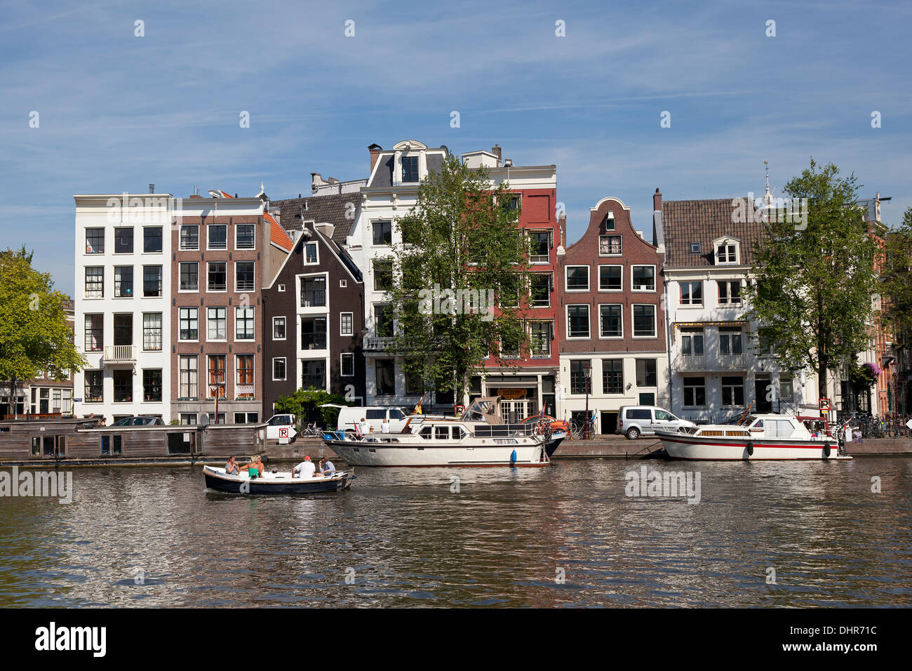 Boating in a canal in Amsterdam with facades of Dutch townhouses Stock Photo
