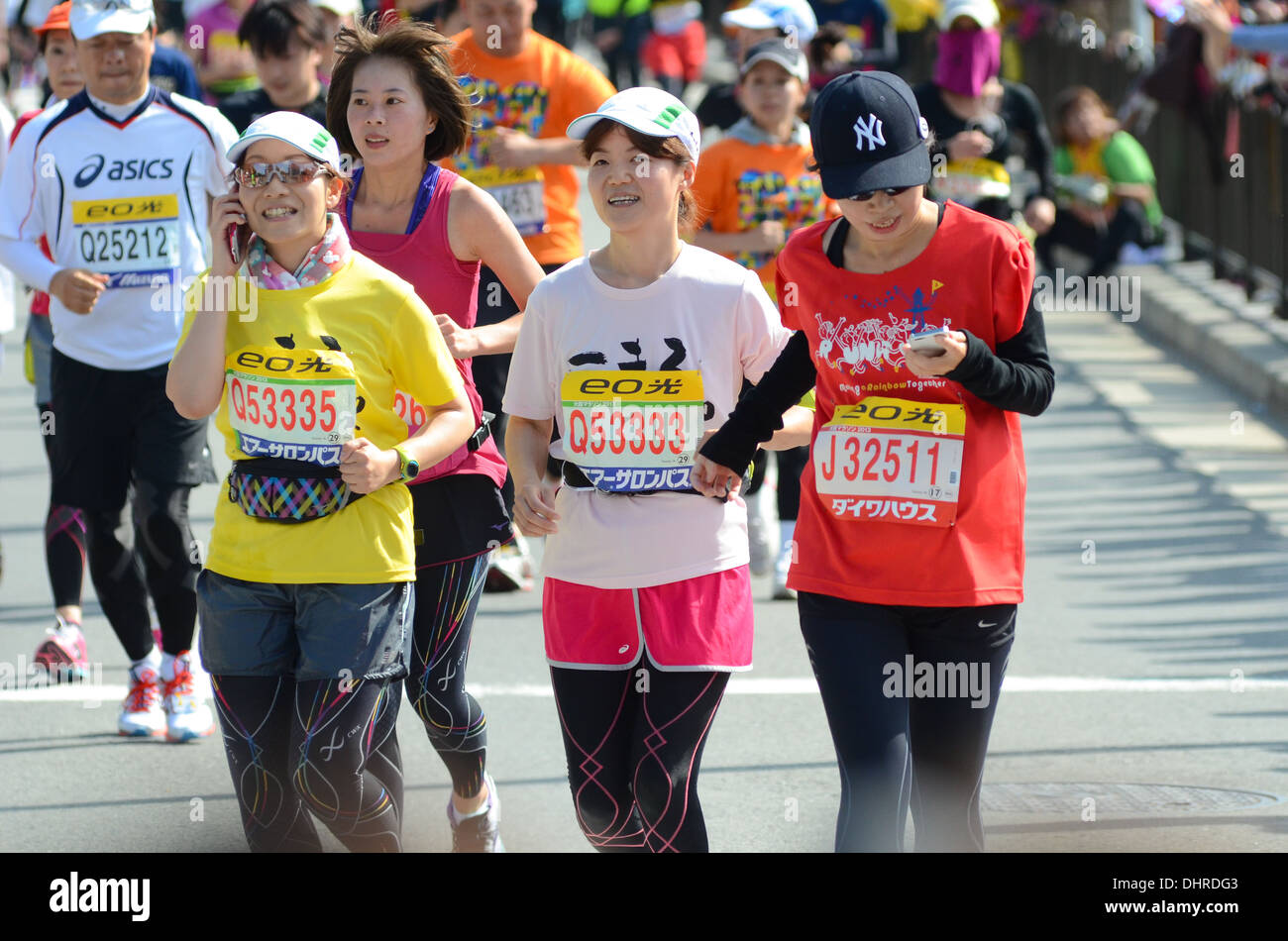 Runners using smartphones during a marathon in Osaka, Japan. Stock Photo