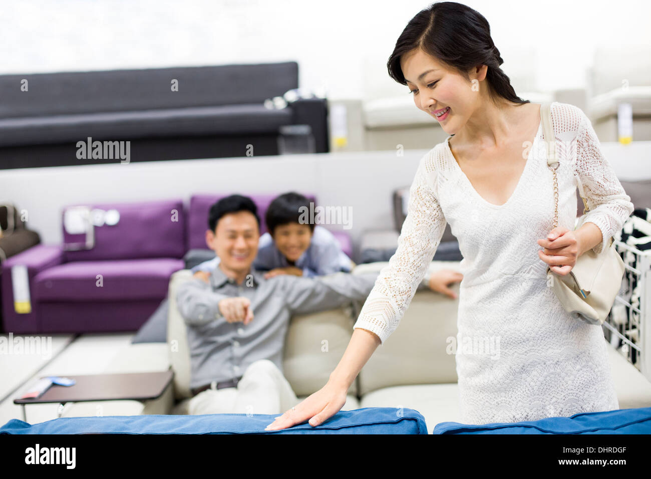 Happy family shopping for sofa in furniture shop Stock Photo Alamy