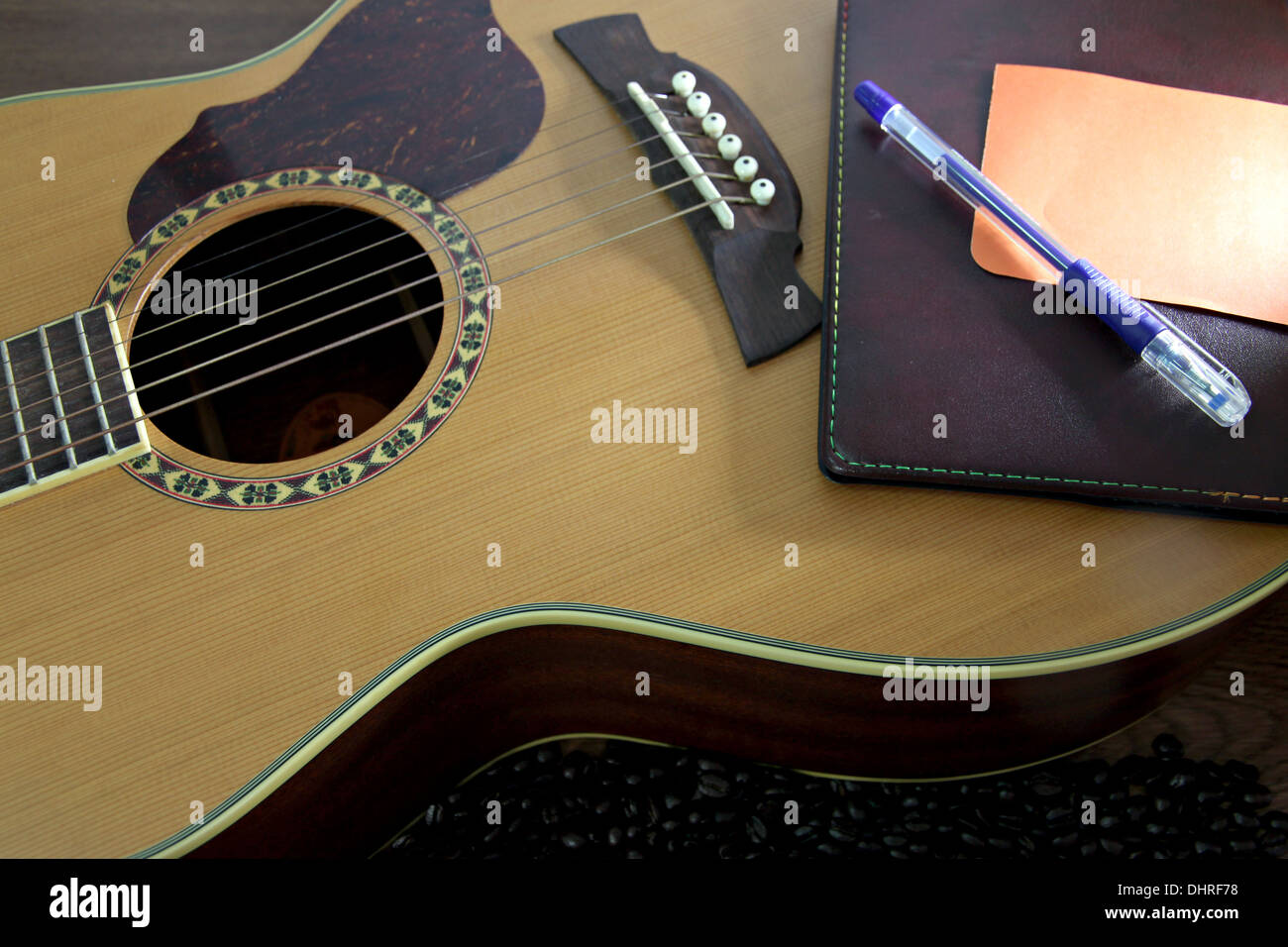The Picture Focus Notebook and Pen resting on the guitar. Stock Photo