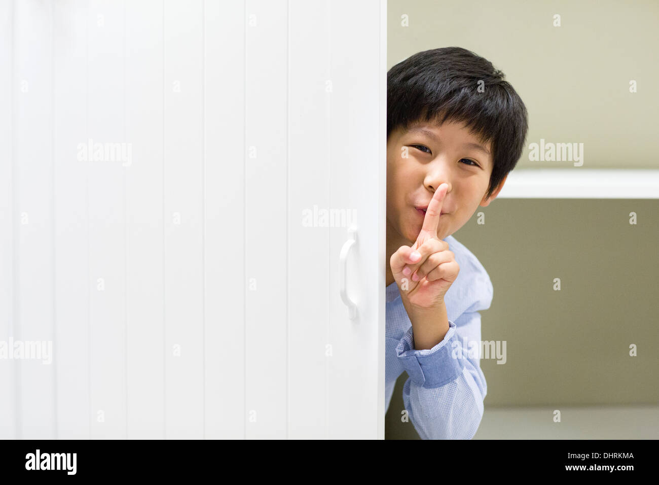 Cute boy hiding behind the door Stock Photo Alamy