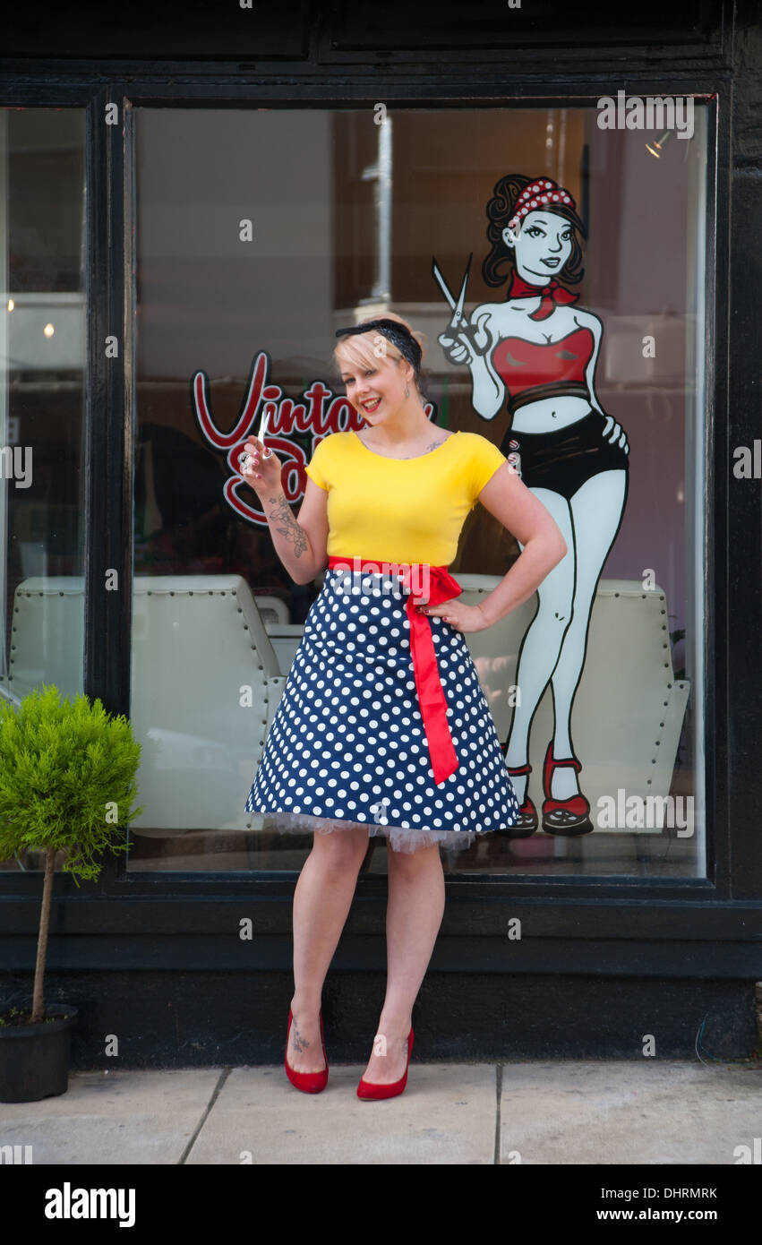 Young woman wearing vintage style clothing outside her hairdressing salon Brighton UK Stock Photo