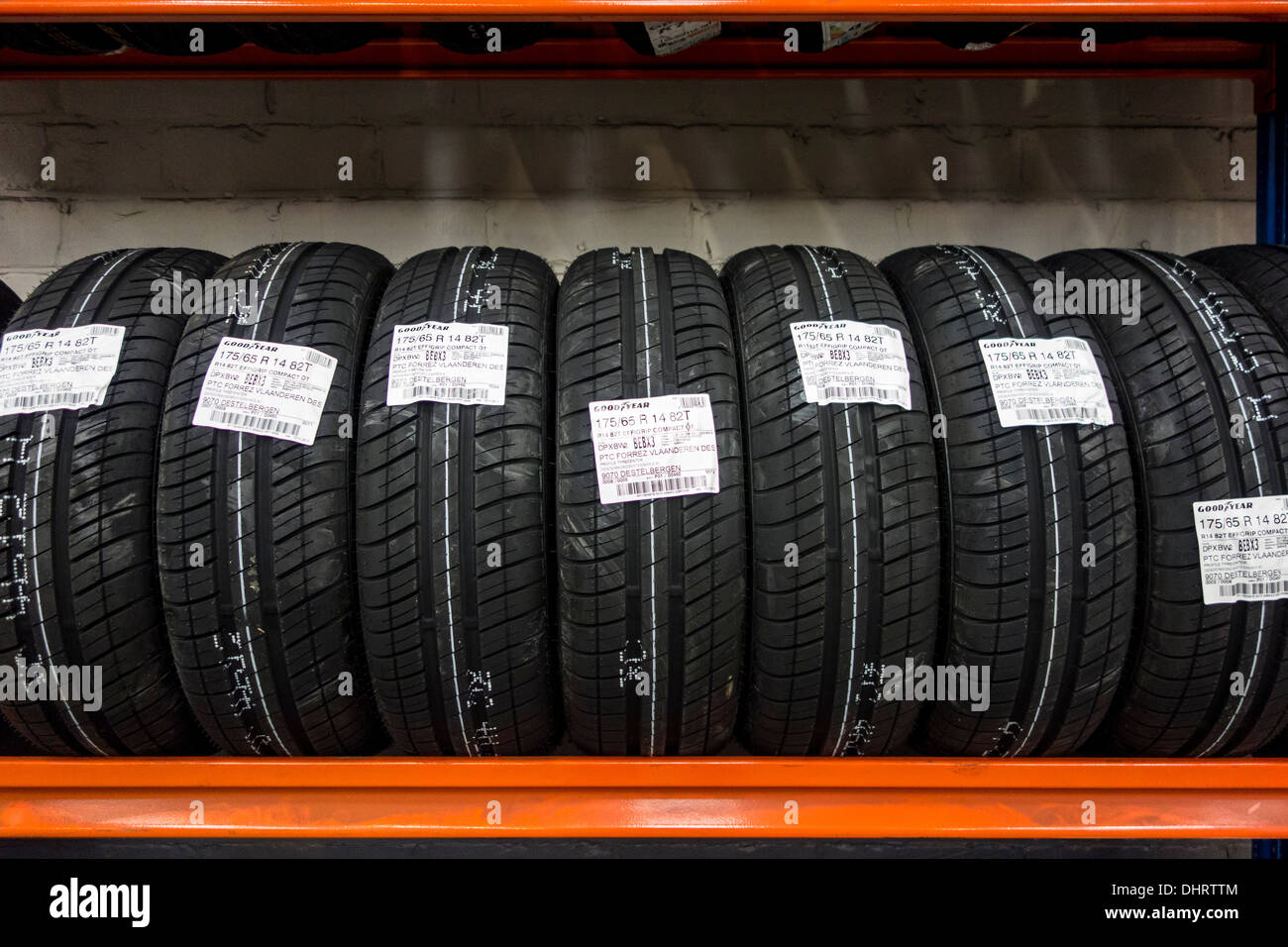 Row of new summer tires for cars stored on shelf in workshop of tire center Stock Photo