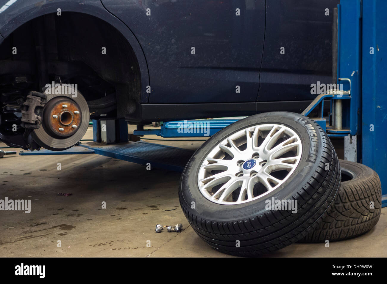 Changing summer tyres and mounting winter tires on wheels of car on ramp in  assembly workshop of tire center Stock Photo - Alamy