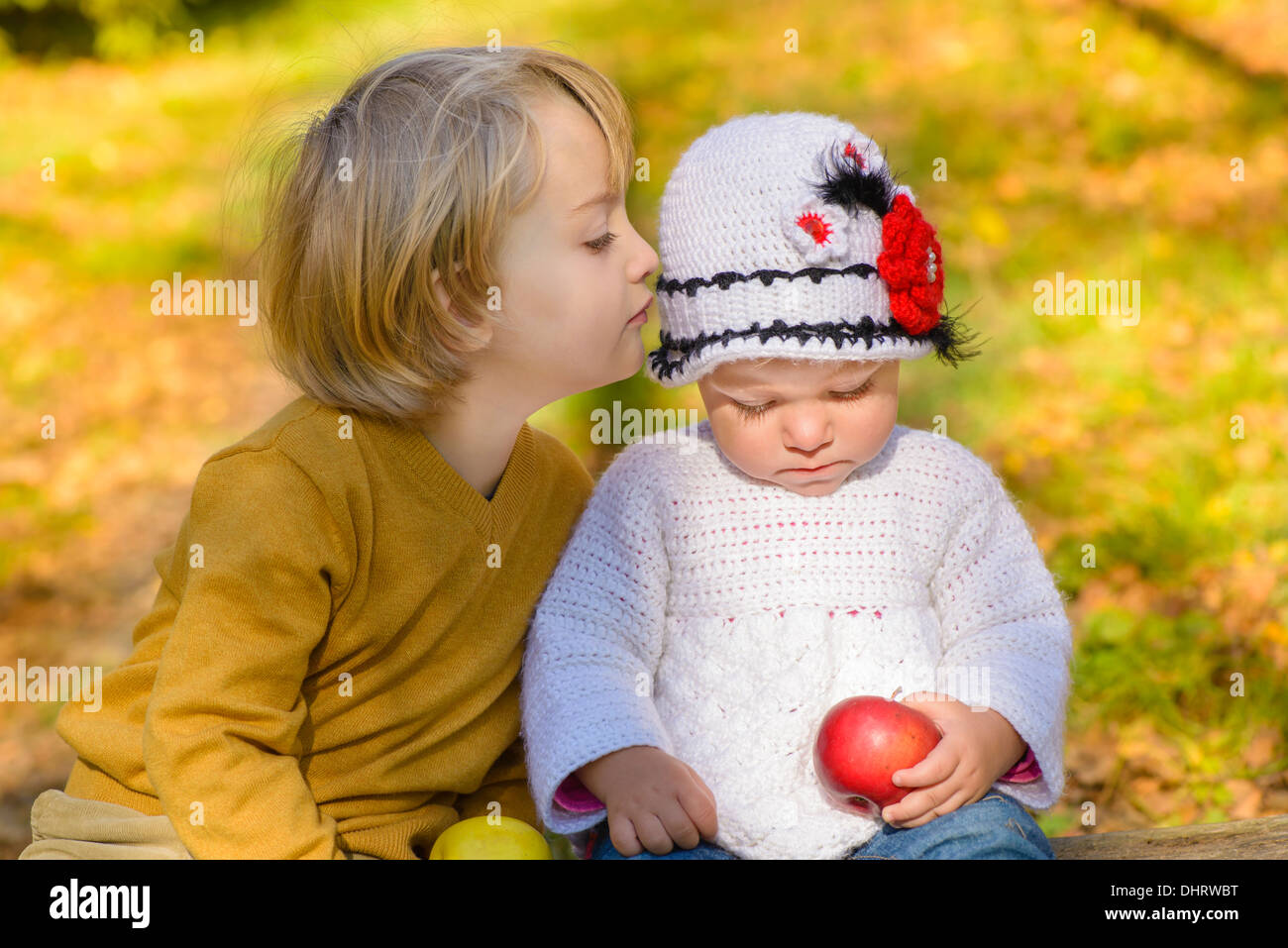 A boy whispering to a girl in a autumn sunlight Stock Photo