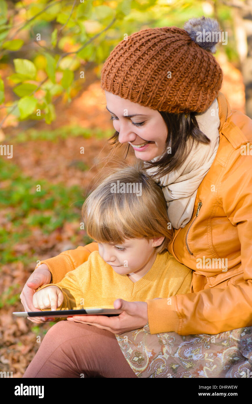 Mother and Son having fun with a tablet pc in a forest in autumn time Stock Photo