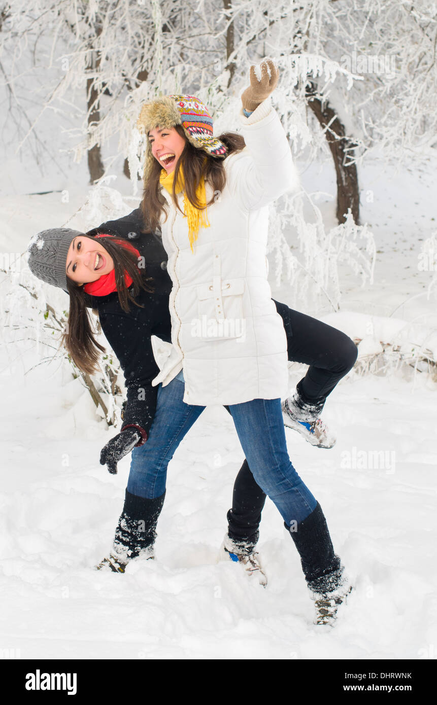 Two young women playing in the snow Stock Photo