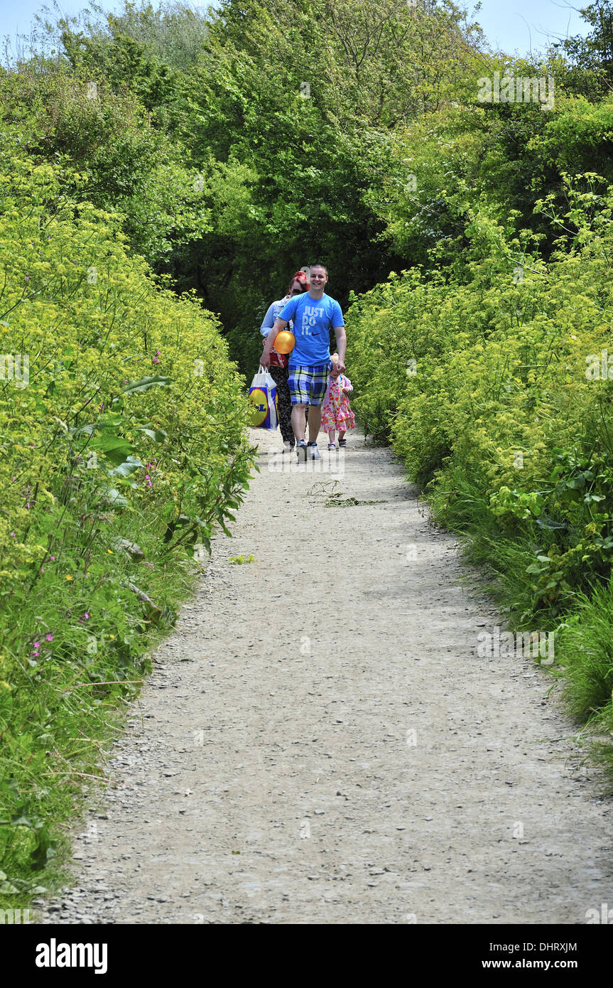 Family walking in spring along footpath  from the village of Croyde towards the sea and Croyde Bay, Devon, England, UK Stock Photo