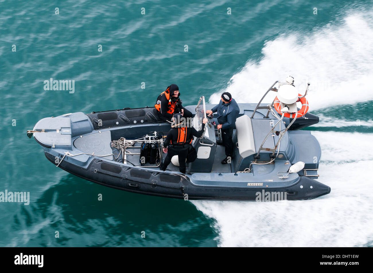 Scuba diving inflatable speedboat going / returning from a dive, three men in wet-suits. Mediterranean, Europe. View from above. Stock Photo