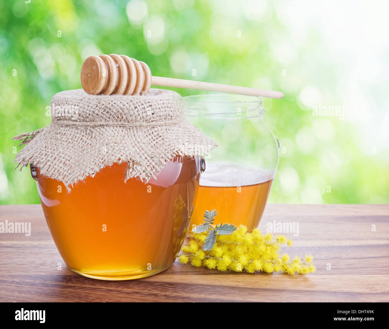 Honey in glass jars against nature bokeh background. Stock Photo