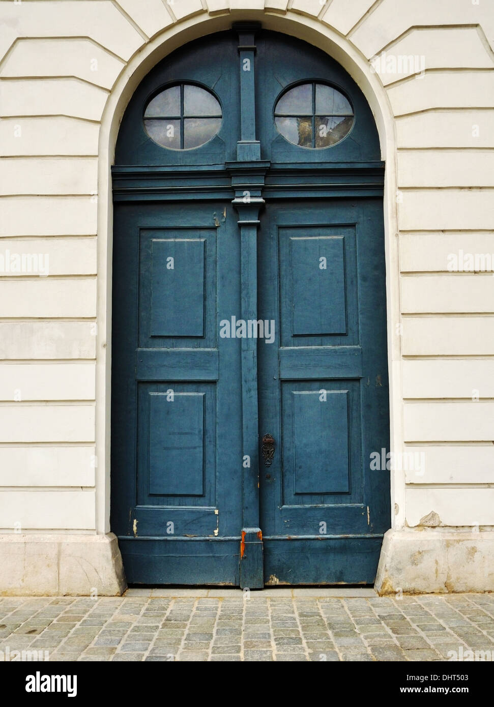 Big blue wooden door with round windows Stock Photo