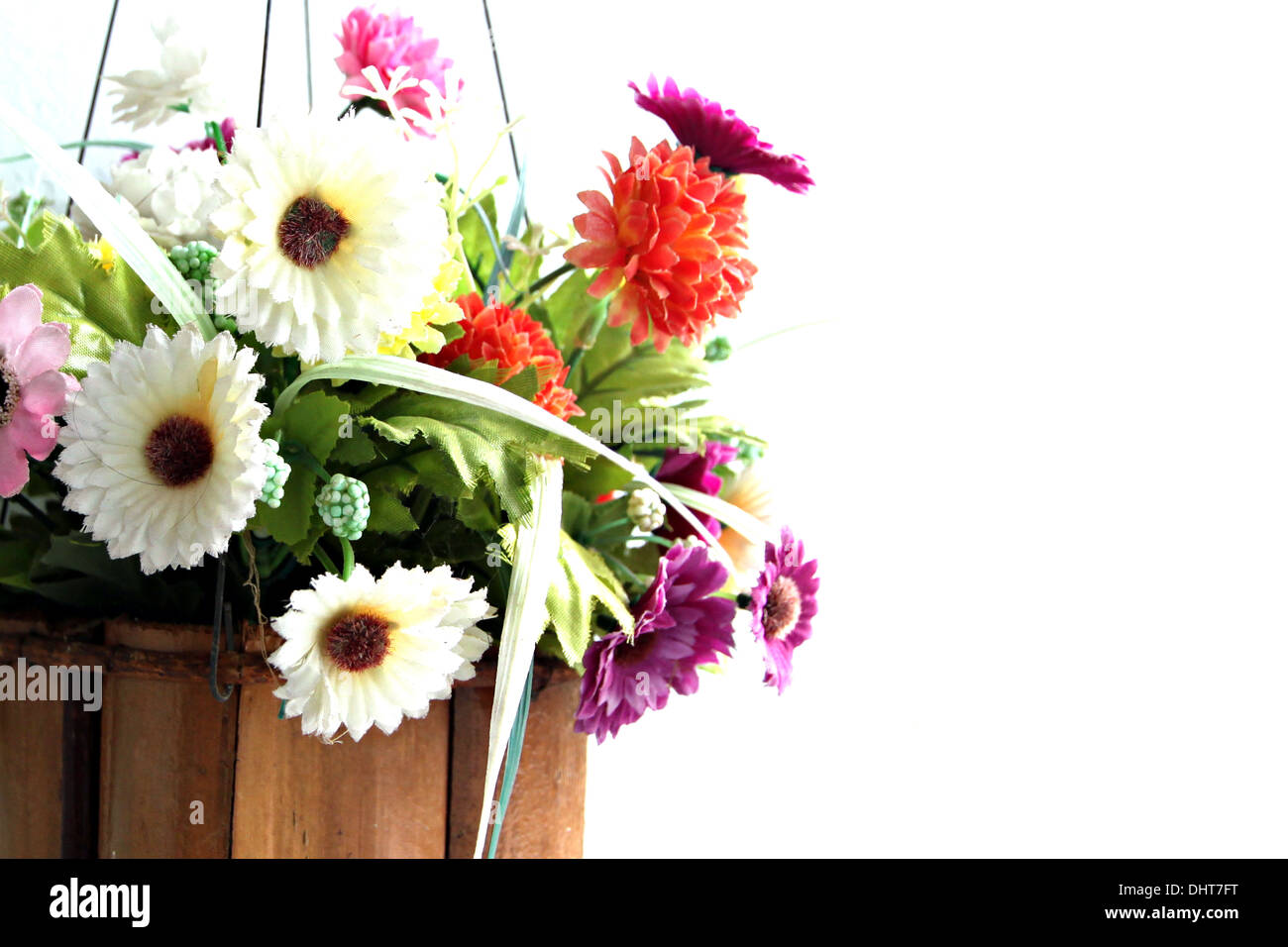 Colorful flowers in a wooden basket and it was hanging out. Stock Photo