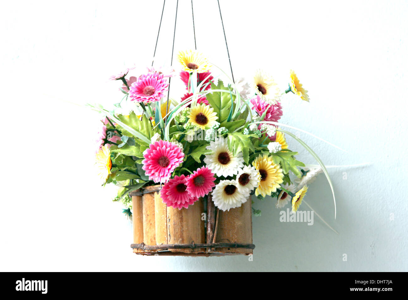 Colorful flowers in a wooden basket and it was hanging out. Stock Photo