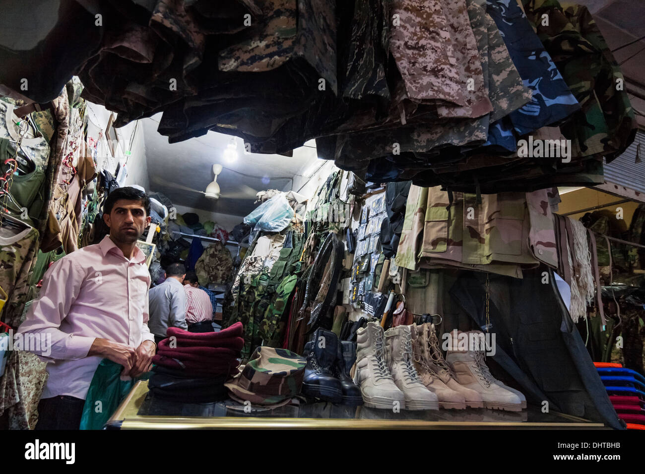 Vendor at bazaar shop selling military gear at Dohuk bazaar, Kurdish Iraq Stock Photo