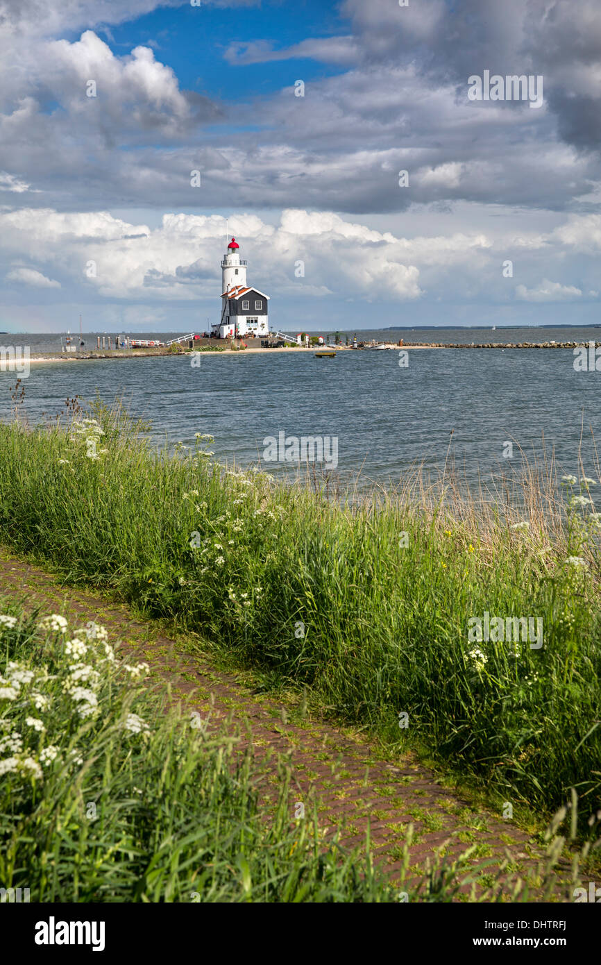 Netherlands, Marken, Lighthouse called Het Paard near lake called IJsselmeer. View from dyke. Jogger Stock Photo
