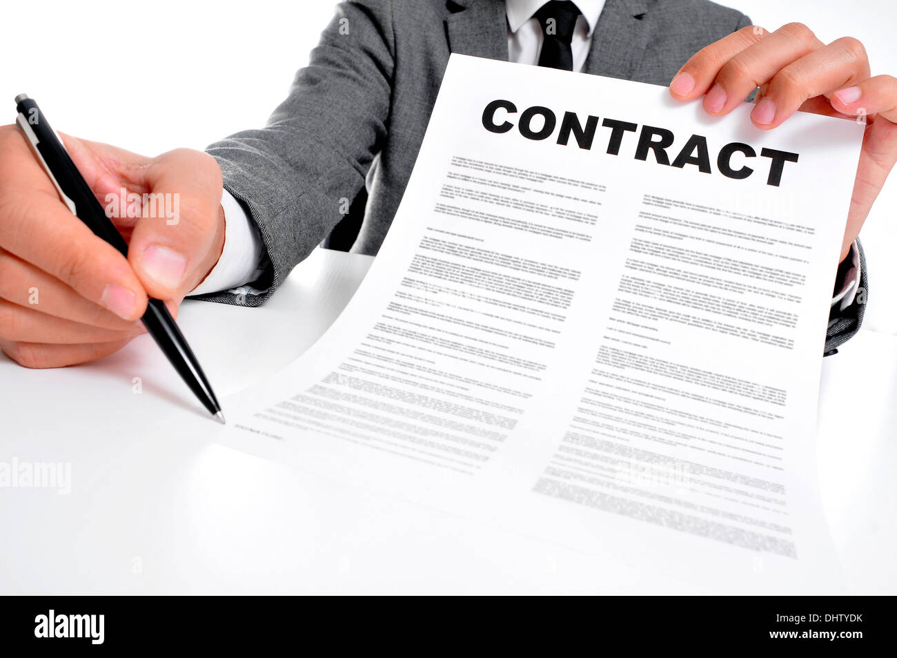 man wearing a suit sitting in a table showing a contract and where the signer must sign Stock Photo