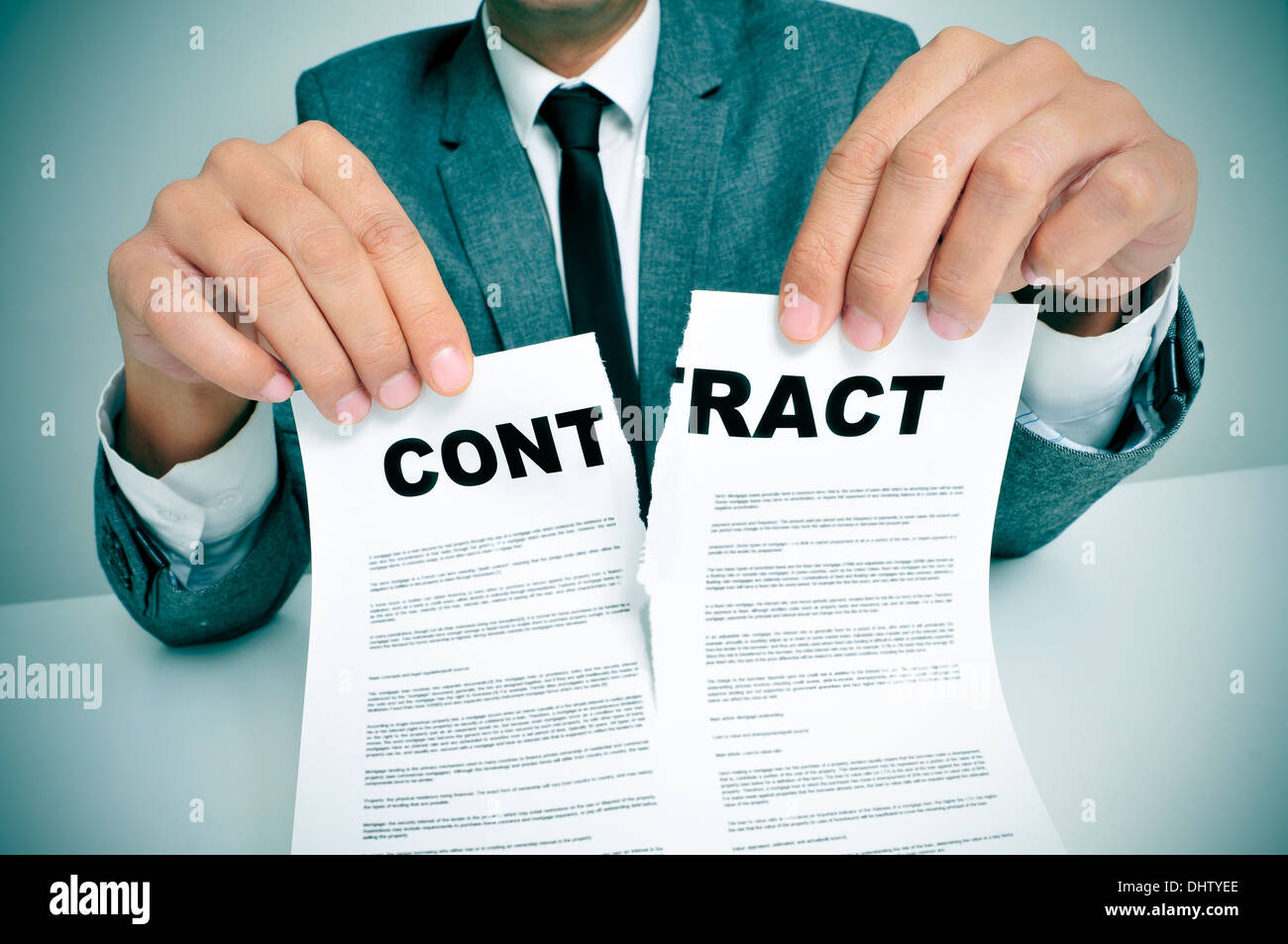 man wearing a suit sitting in a table ripping up a contract Stock Photo man wearing a suit sitting in a table ripping up a contract Stock Photo