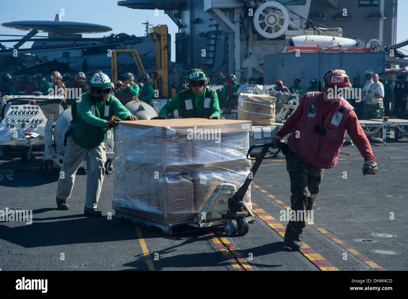 PHILIPPINE SEA (Nov. 15, 2013) Sailors aboard the U.S. Navy's forward deployed aircraft carrier USS George Washington (CVN 73) move a palate of drinking water across the flight deck in support of Operation Damayan. The George Washington Strike Group supports the 3rd Marine Expeditionary Brigade to assist the Philippine government in response to the aftermath of the Super typhoon Haiyan/Yolanda in the Republic of the Philippines. (U.S. Navy photo) Credit:  Foto 23/Alamy Live News Stock Photo