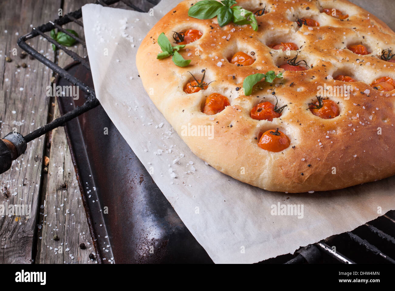 Italian focaccia bread with tomatoes and basil on grill with ...