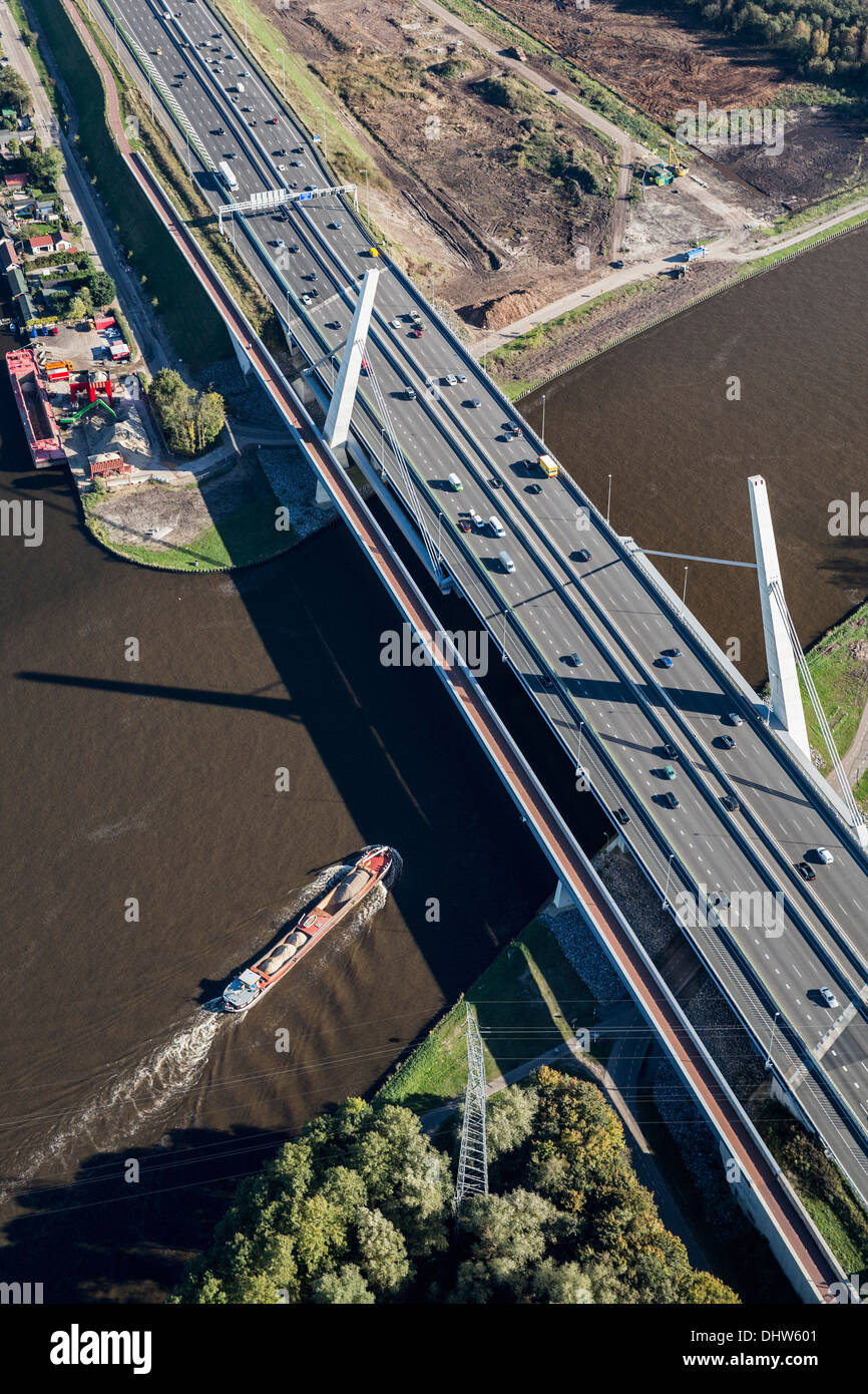 Netherlands, Diemen, A1 highway crossing canal called Amsterdam-Rijnkanaal. Shipping traffic. Aerial Stock Photo